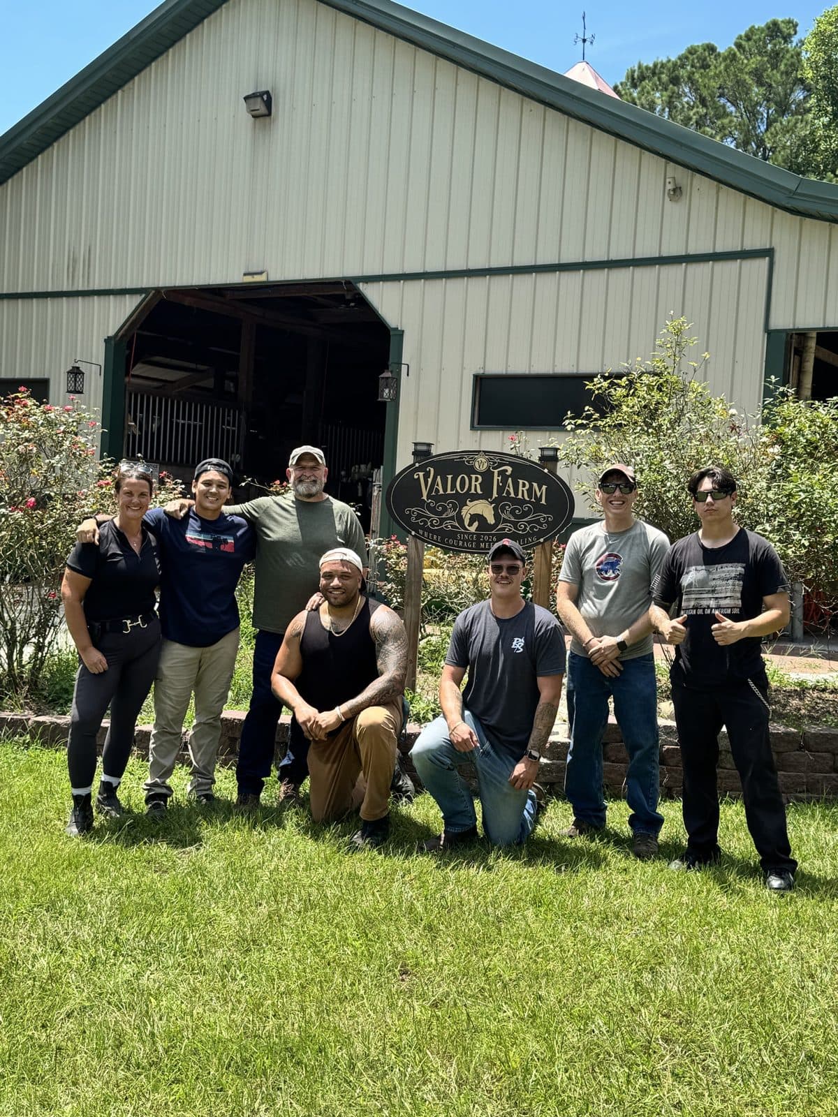Soldiers and volunteers at the Valor Farm sign